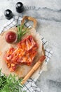 Pork ribs. Raw meat. Raw pork ribs in marinade with spices, rosemary, tomato sauce and garlic on old wooden stand on black stone t Royalty Free Stock Photo