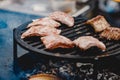 Pork ribs and steak cooked on grill, open fire street food festival