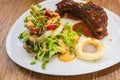 Pork ribs steak and salad in white plate Royalty Free Stock Photo