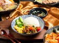 Pork Rice with tomato, cucumber, fork and spoon served in dish isolated on wooden board side view of asian food Royalty Free Stock Photo