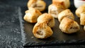 Pork sausage rolls with mustard and ketchup on rustic black stone Royalty Free Stock Photo
