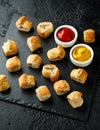 Pork sausage rolls with mustard and ketchup on rustic black stone Royalty Free Stock Photo