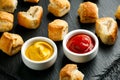 Pork sausage rolls with mustard and ketchup on rustic black stone Royalty Free Stock Photo