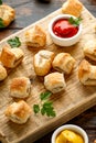 Pork sausage rolls with mustard and ketchup sauce on wooden board Royalty Free Stock Photo