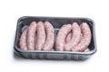 Pork sausages chipolatas in plastic pack isolated on white Royalty Free Stock Photo