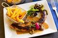 Pork sausages with mushrooms, french fries and lettuce Royalty Free Stock Photo