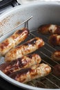 Pork sausages on a rack cooked in an air fryer. Healthy cooking concept