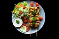 Pork skewers with grilled vegetables served with salad on black background top view Royalty Free Stock Photo