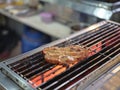 Pork steak cooking over flaming grill Royalty Free Stock Photo