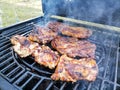 Pork steak on the grill in the yard. Weekend family dinner barbecue. Pork loins bbq steaks Royalty Free Stock Photo