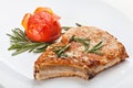 Pork steak with tomato on a plate decorated with a sprig of rose