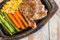 Pork steak with vegetable. Corn, carrots, green beans, on wooden Royalty Free Stock Photo