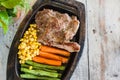 Pork steak with vegetable. Corn, carrots, green beans, on wooden Royalty Free Stock Photo