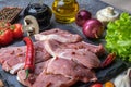 Pork steaks, fresh vegetables, spices close-up on a textured background top view Royalty Free Stock Photo