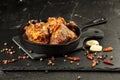 Pork stew in frying pan with species on black background, close up view Royalty Free Stock Photo