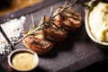 Pork tenderloin with mashed potatos, bacon and mustard sauce with branch of smoking rosemary. Delicious healthy Royalty Free Stock Photo