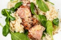 Pork tenderloin medallions on risotto with parmesan and spinach leaf,closeup Royalty Free Stock Photo