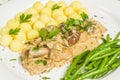 Pork tenderloin with potatoes and wild mushroom sauce and green beans on white plate Royalty Free Stock Photo