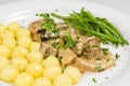 Pork tenderloin with potatoes and wild mushroom sauce and green beans on white plate Royalty Free Stock Photo