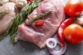 Pork tenderloin with rosemary, onions, chili peppers and tomatoes, raw meat with vegetables and herbs Royalty Free Stock Photo