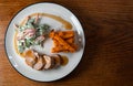 Pork tenderloin with salad, gravy and sweet potato fries served on a white plate top view Royalty Free Stock Photo