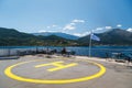 Poros, Cephalonia island, Greece - July, 17 2019: Yellow sign of helipad for helicopters at the ship and passengers relaxing at