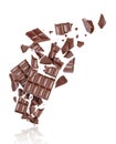 Porous chocolate broken into many pieces in the air, isolated on a white background