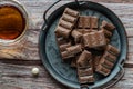 Aerated dark chocolate on a white plate on a wooden table background with a cup of tea Royalty Free Stock Photo