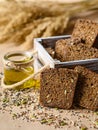 Porous slices of dark rye bread with seeds close-up. Nearby is olive oil. Vertical format. Royalty Free Stock Photo