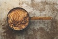 Porridge with Apple Slices, Granola, and Cinammon in Copper Saucepan Royalty Free Stock Photo
