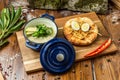 Porridge in a cast-iron pot with lavash and herbs on a wooden board