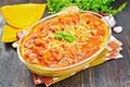 Porridge corn with meat and vegetables in roaster on dark board Royalty Free Stock Photo