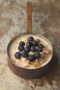 Porridge with Blueberries in Copper Saucepan on Weathered Stainless Steel Surface Royalty Free Stock Photo