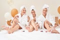 Friends in towels and bathrobes doing pedicure.