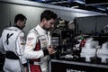 Porsche drivers and pit crew in the pits of Monza