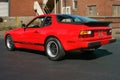 Porsche 944 in red back side in front of brick factory