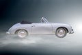 Porsche 356 sports car in side view with curved rounded bodywork in front of foggy background