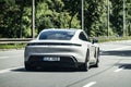 Porsche Taycan 4 S electric sedan driving quickly with slight motion blur effect