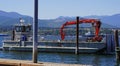 Flat bottomed work boat with crane hoist docks in Port Angeles, Washington