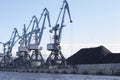 The Port blue cranes load coal into vagon. The territory of the coal port near the river