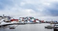 Port with boats and colorful Inuit houses on the rocks in backgr Royalty Free Stock Photo