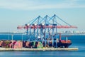 Port cargo crane loads a container onto a cargo ship