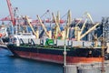 Port cargo crane loads a container onto a cargo ship in a seaport