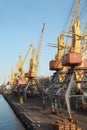 Port cargo cranes over blue sky background