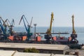 The port cranes load coal into ships