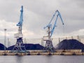 Port cranes for loading and unloading coal into freight trains. Coal transportation Royalty Free Stock Photo