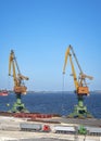 Port cranes ready to load containers from cargo ships.