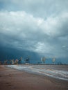 Port cranes under the dark clouds after the thunderstorm. Dramatic stormy sky. Industrial landscape. Idle cranes in front of storm