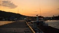 A port deck small on the remote island on sunrise with black shadow and orange sky