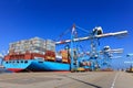Port dock with container ship and Various brands and colors of shipping containers stacked in a holding platform Royalty Free Stock Photo
